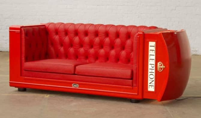 Red tufted sofa designed in the shape of a vintage British telephone booth with 'TELEPHONE' text on the side.