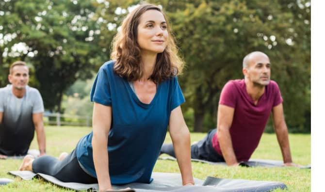 Yoga stretching in a park,