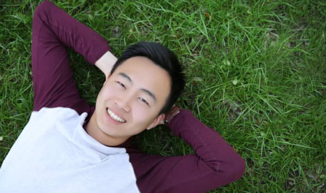 man lying on his back in grass