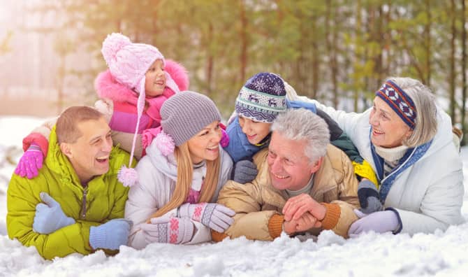 Family lying together in snow.