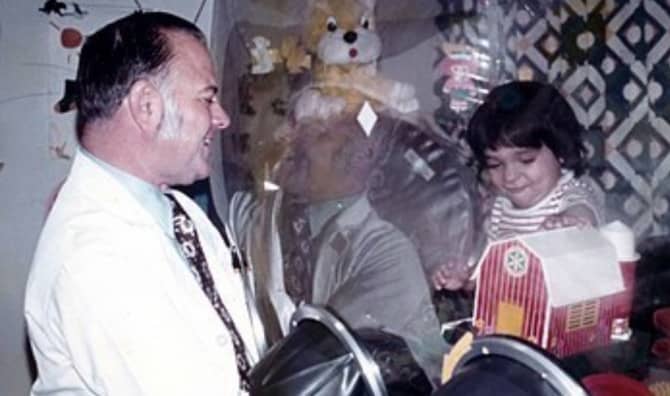 Older man looking at a kid behind a plastic cover