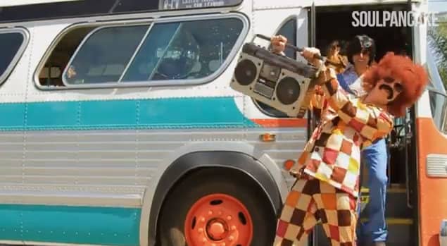 Man playing disco infront of a bus