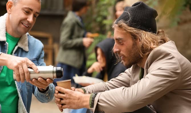 Giving a drink to a man on the street.