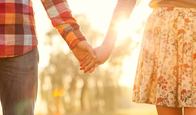 Two people hold hands.