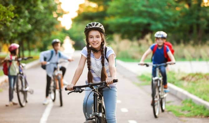 A group of children ride their bicycles.
