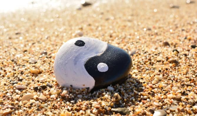 Yin and Yang painted on a rock by the sea.
