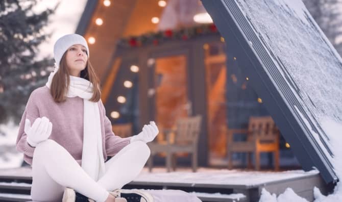 Woman meditating outside in winter.
