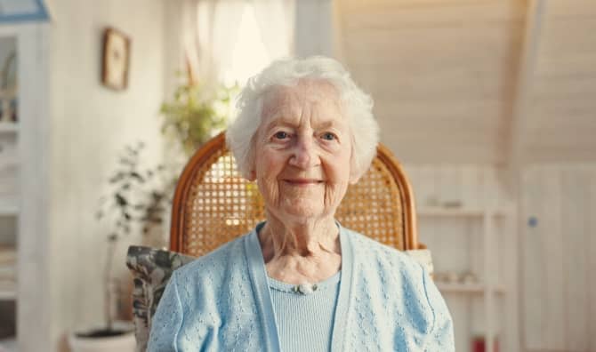 An elderly woman smiles.