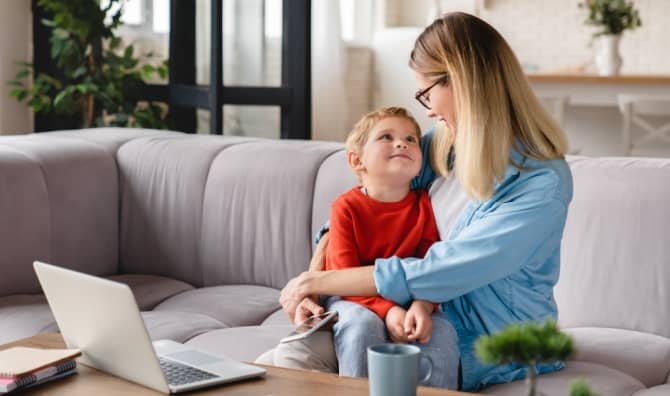 A mother and her child sit on a couch.
