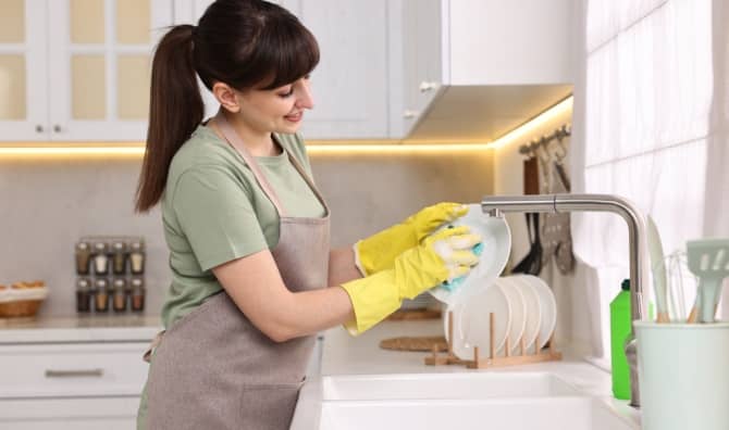 A woman washes a dish.