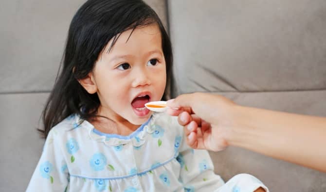 Girl taking her medicine.