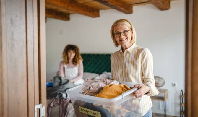 A woman holds a donation box.