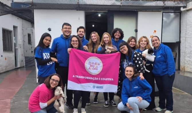 Volunteers pose with rescued dogs and cats while holding a Good Deeds Day banner at an animal shelter in São Paulo, Brazil.