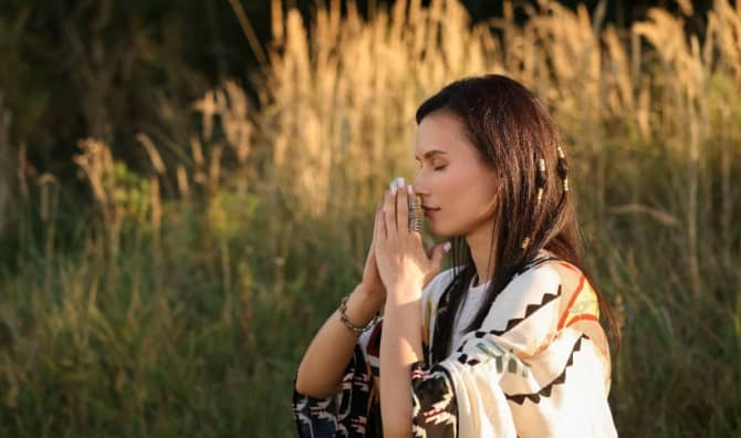 Woman meditating with crystal to find balance.