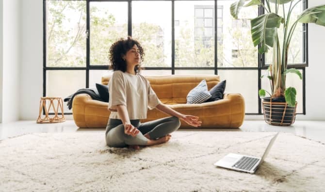 A woman meditating at home.