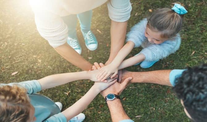 A family enjoying nature are supporting each other, embodying hope.