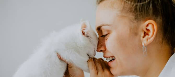 A woman holds a kitten.