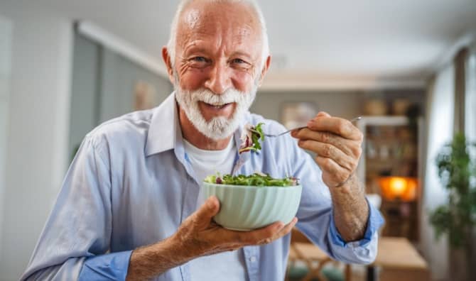 A man eats a salad.