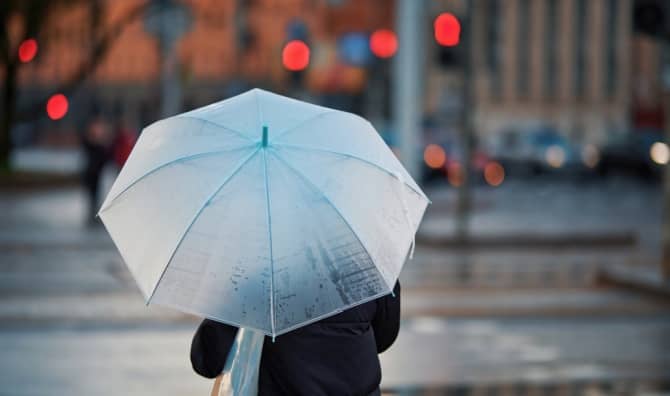 Using an old-fashioned umbrella on a rainy day.