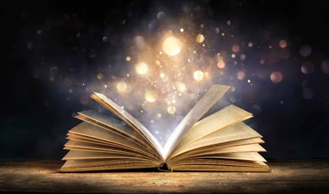 An open antique book softly glows with warm golden light.