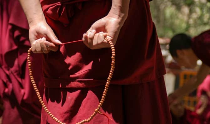 Tibetan Buddhist Monk with his red robe and prayer beads.