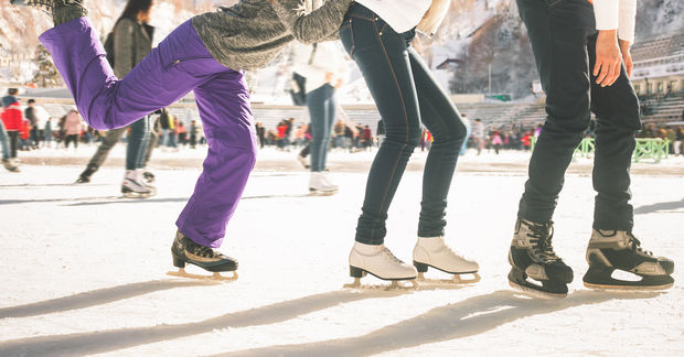 People ice skating on outdoor rink.