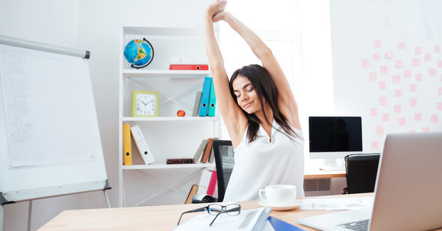 woman stretching on a chair in an office