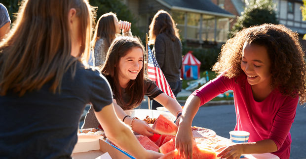 photo Girls socializing and eating watermelon at outdoor gathering.