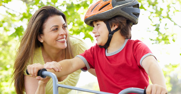 photo Mother and child with bike helmet outdoors.