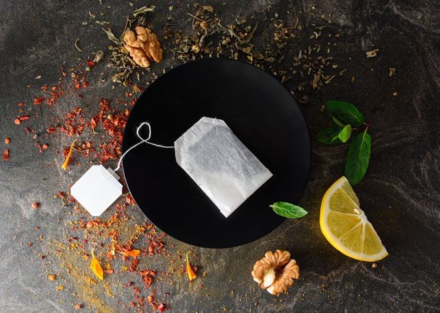 Old teabag on a black plate