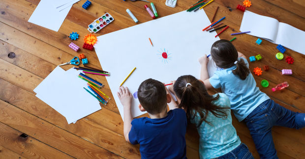 photo Three kids drawing and painting on a white paper
