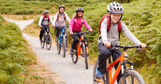 photo Happy family riding bikes on outdoor trail.
