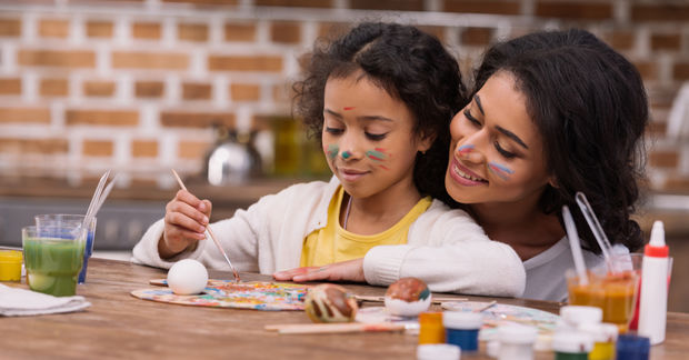 photo Mother and daughter painting together at table.