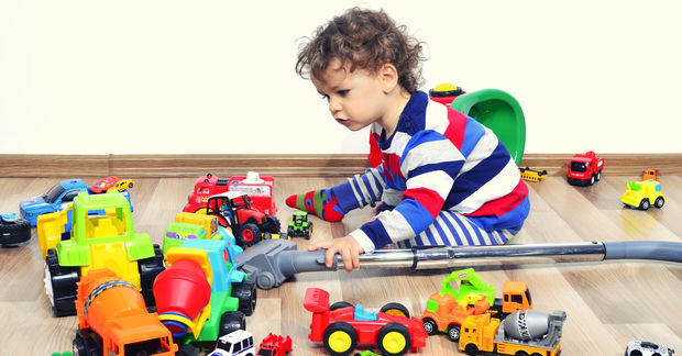 photo Toddler playing with colorful toy cars indoors.