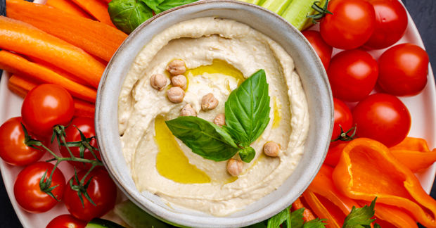 Hummus bowl with fresh vegetables and cherry tomatoes.