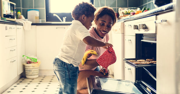 Couple embracing while baking in kitchen.