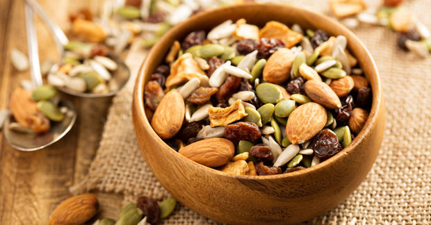 Wooden bowl filled with mixed nuts and seeds.