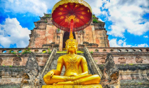 A pagoda and buddha statue at Wat Chedi Luang temple in Chiang Mai.