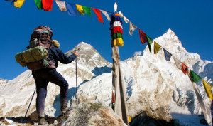A view of Everest with hiker and buddhist prayer flags.